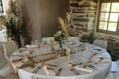 Miniature Location salle Plélan-le-Grand (Ille-et-Vilaine) - Domaine Le 5b #59 Table ronde décorée pour un repas, avec nappes blanches, couverts disposés, fleurs et éléments naturels en centre de table.