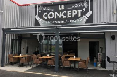 Salle décorée pour un anniversaire avec ballons noirs et dorés, tables dressées et une scène en fond.