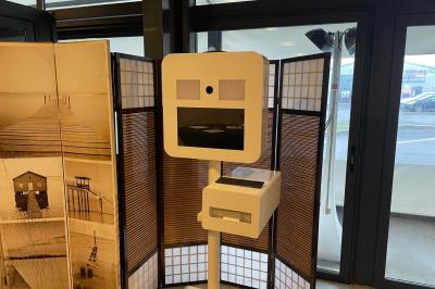 Salle décorée pour un anniversaire avec ballons noirs et dorés, tables dressées et une scène en fond.