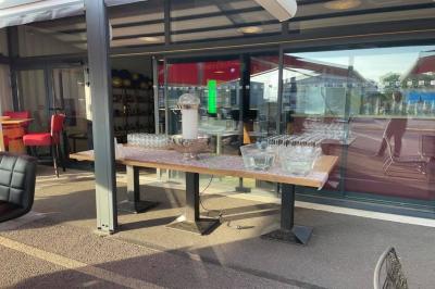 Salle décorée pour un anniversaire avec ballons noirs et dorés, tables dressées et une scène en fond.