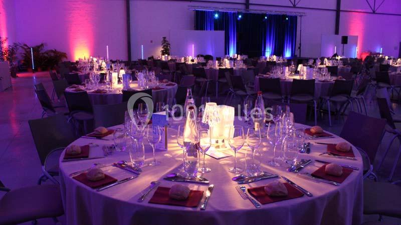 Location salle Dammarie-les-Lys (Seine-et-Marne) - Espace Pierre Bachelet #2 Salle de réception décorée avec des tables rondes dressées, éclairage coloré et ambiance festive.