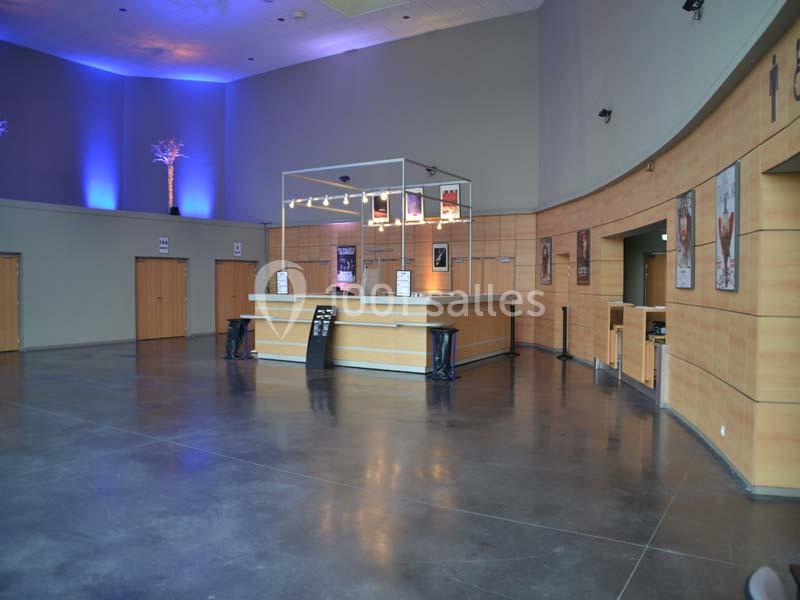 Location salle Dammarie-les-Lys (Seine-et-Marne) - Espace Pierre Bachelet #23 Hall d'accueil spacieux avec comptoir en bois, murs courbes, éclairage tamisé et affiches décoratives.