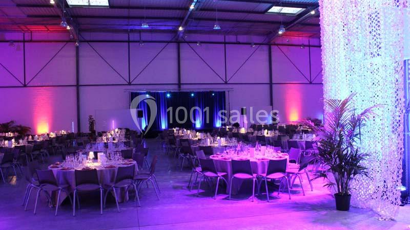 Location salle Dammarie-les-Lys (Seine-et-Marne) - Espace Pierre Bachelet #3 Salle de réception décorée avec des tables dressées, éclairage coloré et rideaux lumineux en arrière-plan.