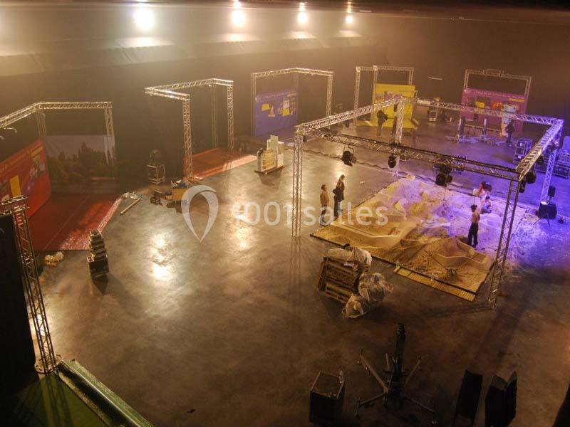 Location salle Dammarie-les-Lys (Seine-et-Marne) - Espace Pierre Bachelet #17 Montage d'une exposition dans un grand espace intérieur avec des structures métalliques et des panneaux colorés.