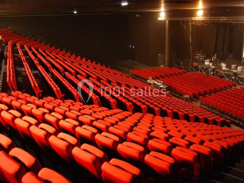 Location salle Dammarie-les-Lys (Seine-et-Marne) - Espace Pierre Bachelet #8 Rangées de fauteuils rouges alignées dans une grande salle de spectacle vide avec une scène en arrière-plan.