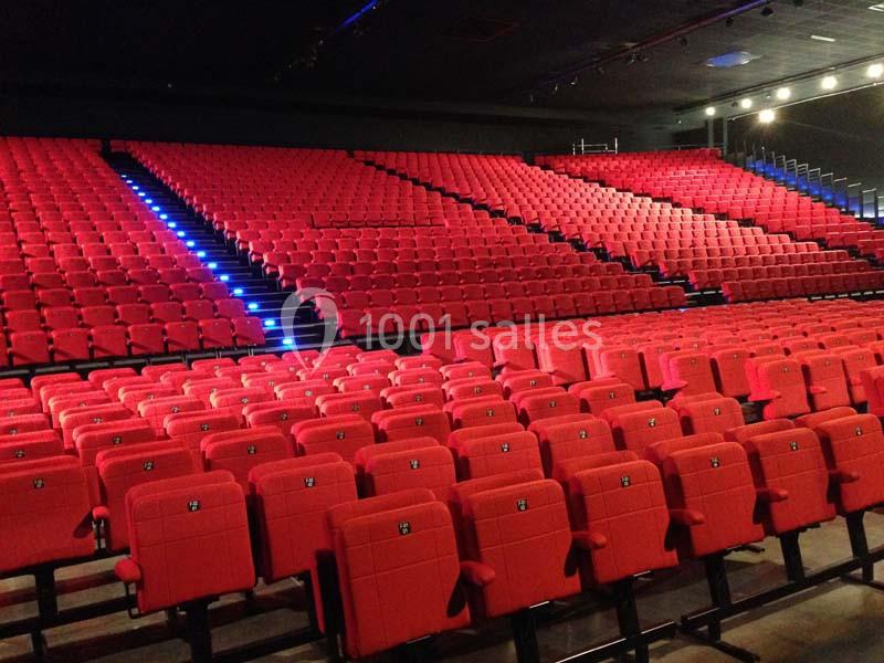 Location salle Dammarie-les-Lys (Seine-et-Marne) - Espace Pierre Bachelet #10 Salle de spectacle avec de nombreuses rangées de sièges rouges vides et un éclairage discret.