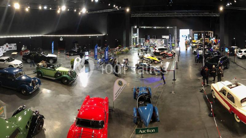 Location salle Dammarie-les-Lys (Seine-et-Marne) - Espace Pierre Bachelet #21 Vue d'une exposition de voitures classiques et modernes dans une grande salle éclairée, avec quelques visiteurs.