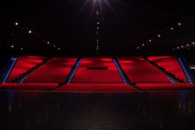 Entrée vitrée illuminée avec des plantes en pot disposées en rangées et éclairage coloré.