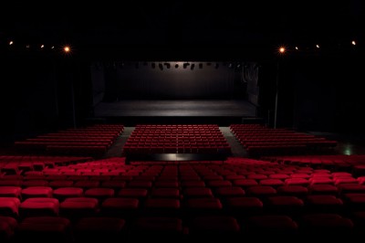 Entrée vitrée illuminée avec des plantes en pot disposées en rangées et éclairage coloré.