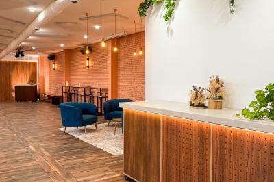 Salon chaleureux avec canapé jaune, fauteuils en rotin, table basse ronde, lampes et décorations murales abstraites.