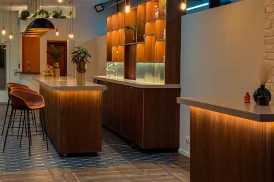 Salon chaleureux avec canapé jaune, fauteuils en rotin, table basse ronde, lampes et décorations murales abstraites.