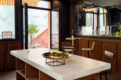 Salon cosy avec canapé jaune, fauteuils en rotin, table basse ronde, lampes et décorations murales dans une ambiance…