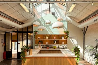 Salon cosy avec canapé jaune, fauteuils en rotin, table basse ronde, lampes et décorations murales dans une ambiance…