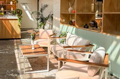 Salon cosy avec canapé jaune, fauteuils en rotin, table basse ronde, lampes et décorations murales dans une ambiance…