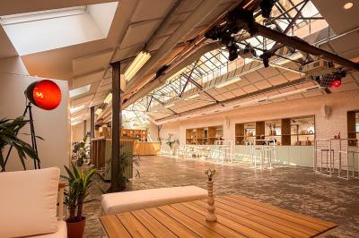 Salon cosy avec canapé jaune, fauteuils en rotin, table basse ronde, lampes et décorations murales dans une ambiance…