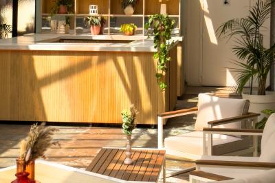 Salon cosy avec canapé jaune, fauteuils en rotin, table basse ronde, lampes et décorations murales dans une ambiance…