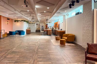 Salon cosy avec canapé jaune, fauteuils en rotin, table basse ronde, lampes et décorations murales dans une ambiance…