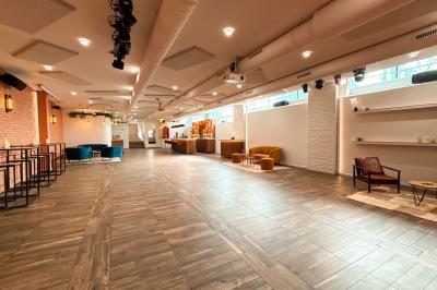 Salon cosy avec canapé jaune, fauteuils en rotin, table basse ronde, lampes et décorations murales dans une ambiance…