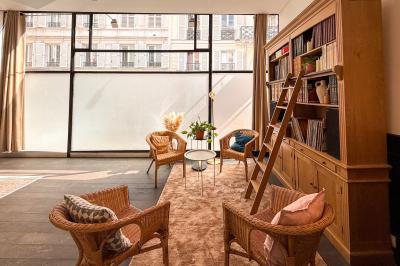 Salon cosy avec canapé jaune, fauteuils en rotin, table basse ronde, lampes et décorations murales dans une ambiance…