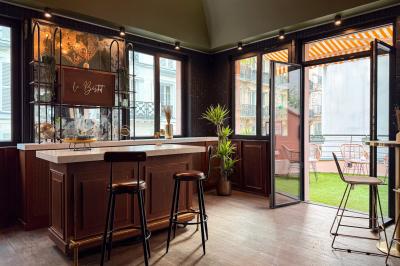 Salon cosy avec canapé jaune, fauteuils en rotin, table basse ronde, lampes et décorations murales dans une ambiance…