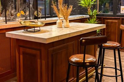 Salon cosy avec canapé jaune, fauteuils en rotin, table basse ronde, lampes et décorations murales dans une ambiance…