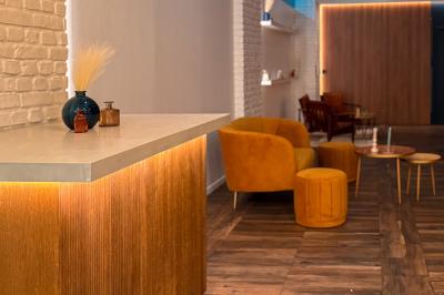 Salon cosy avec canapé jaune, fauteuils en rotin, table basse ronde, lampes et décorations murales dans une ambiance…