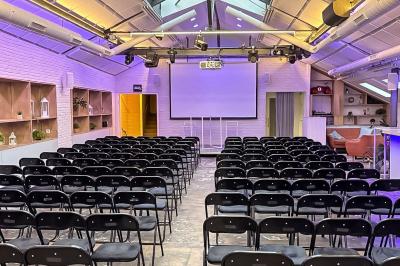 Salon cosy avec canapé jaune, fauteuils en rotin, table basse ronde, lampes et décorations murales dans une ambiance…