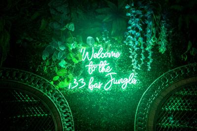 Deux lits simples avec tête de lit noire, coussins jaunes, et tableaux d'animaux anthropomorphes au mur.