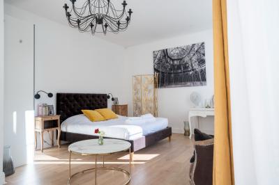 Deux lits simples avec tête de lit noire, coussins jaunes, et tableaux d'animaux anthropomorphes au mur.