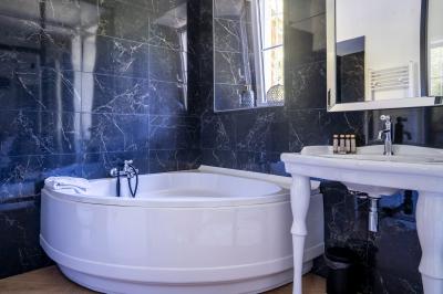 Deux lits simples avec tête de lit noire, coussins jaunes, et tableaux d'animaux anthropomorphes au mur.