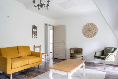 Deux lits simples avec tête de lit noire, coussins jaunes, et tableaux d'animaux anthropomorphes au mur.