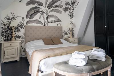 Deux lits simples avec tête de lit noire, coussins jaunes, et tableaux d'animaux anthropomorphes au mur.