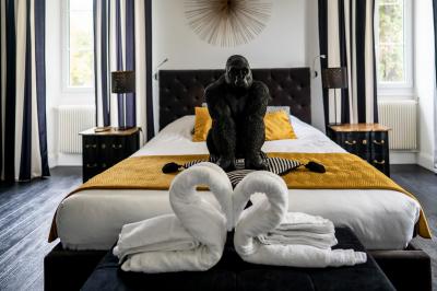 Deux lits simples avec tête de lit noire, coussins jaunes, et tableaux d'animaux anthropomorphes au mur.