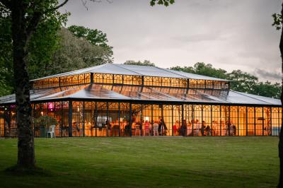 Miniature @la_photographe_de_mariage Salle de bain avec baignoire sur pieds, douche vitrée, lavabo, toilettes et carrelage beige décoré de motifs floraux.