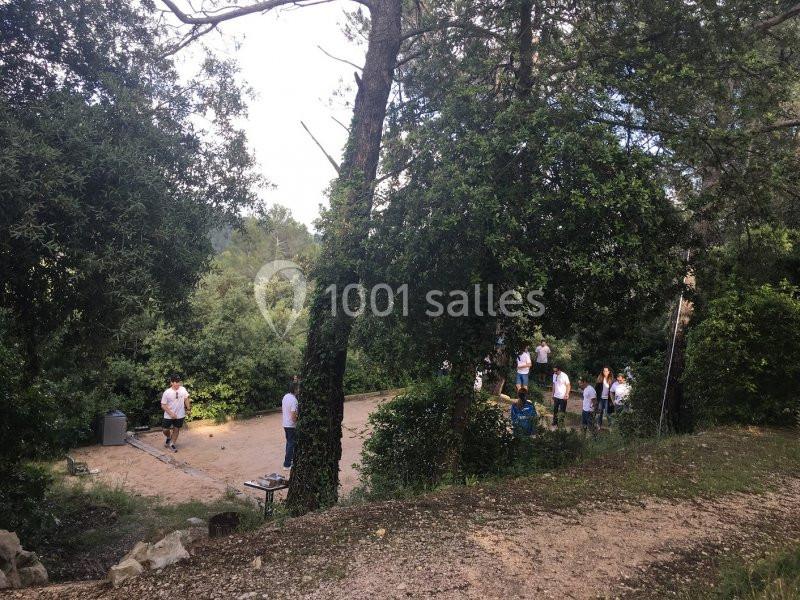 Un groupe de personnes en t-shirts blancs se rassemble dans une clairière entourée d'arbres en pleine nature.