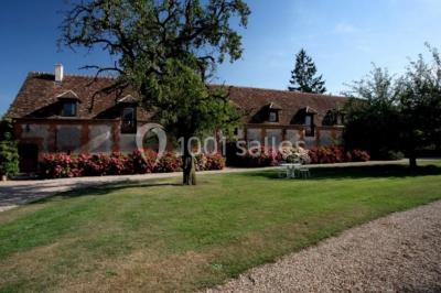Miniature Location salle Amécourt (Eure) - Domaine du Patis #9 Chambre lumineuse avec poutres apparentes, lit double, table blanche, et vue sur un balcon avec verdure.