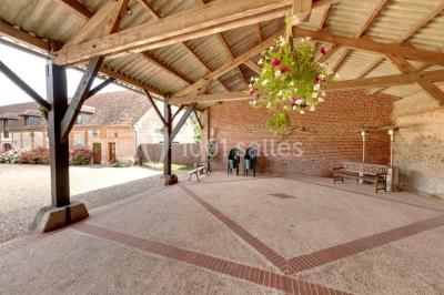 Miniature Location salle Amécourt (Eure) - Domaine du Patis #2 Chambre lumineuse avec poutres apparentes, lit double, table blanche, et vue sur un balcon avec verdure.