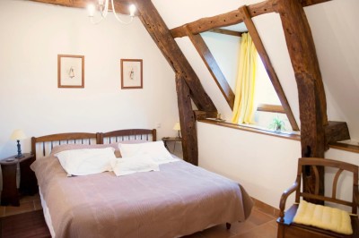 Miniature Location salle Amécourt (Eure) - Domaine du Patis #25 Chambre mansardée lumineuse avec lit simple, poutres apparentes, fenêtre, table de chevet et étagère en bois.