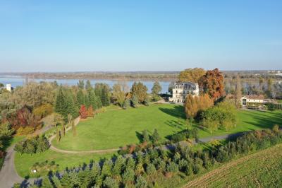 Miniature Location salle Blanquefort (Gironde) - Château Grattequina #4 Vue d'une salle de bain avec double vasque en bois et d'une chambre lumineuse avec parquet et grandes fenêtres.