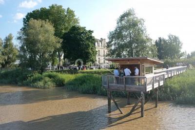 Miniature Carrelet  Vue d'une salle de bain avec double vasque en bois et d'une chambre lumineuse avec parquet et grandes fenêtres.