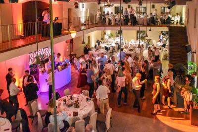 Miniature Pavillon - Dîner dansant Vue d'une salle de bain avec double vasque en bois et d'une chambre lumineuse avec parquet et grandes fenêtres.