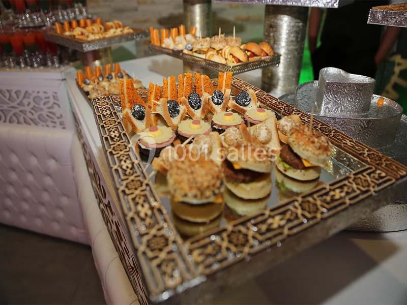 Plateau de petits fours variés présentés sur un support décoratif en métal lors d'un buffet.