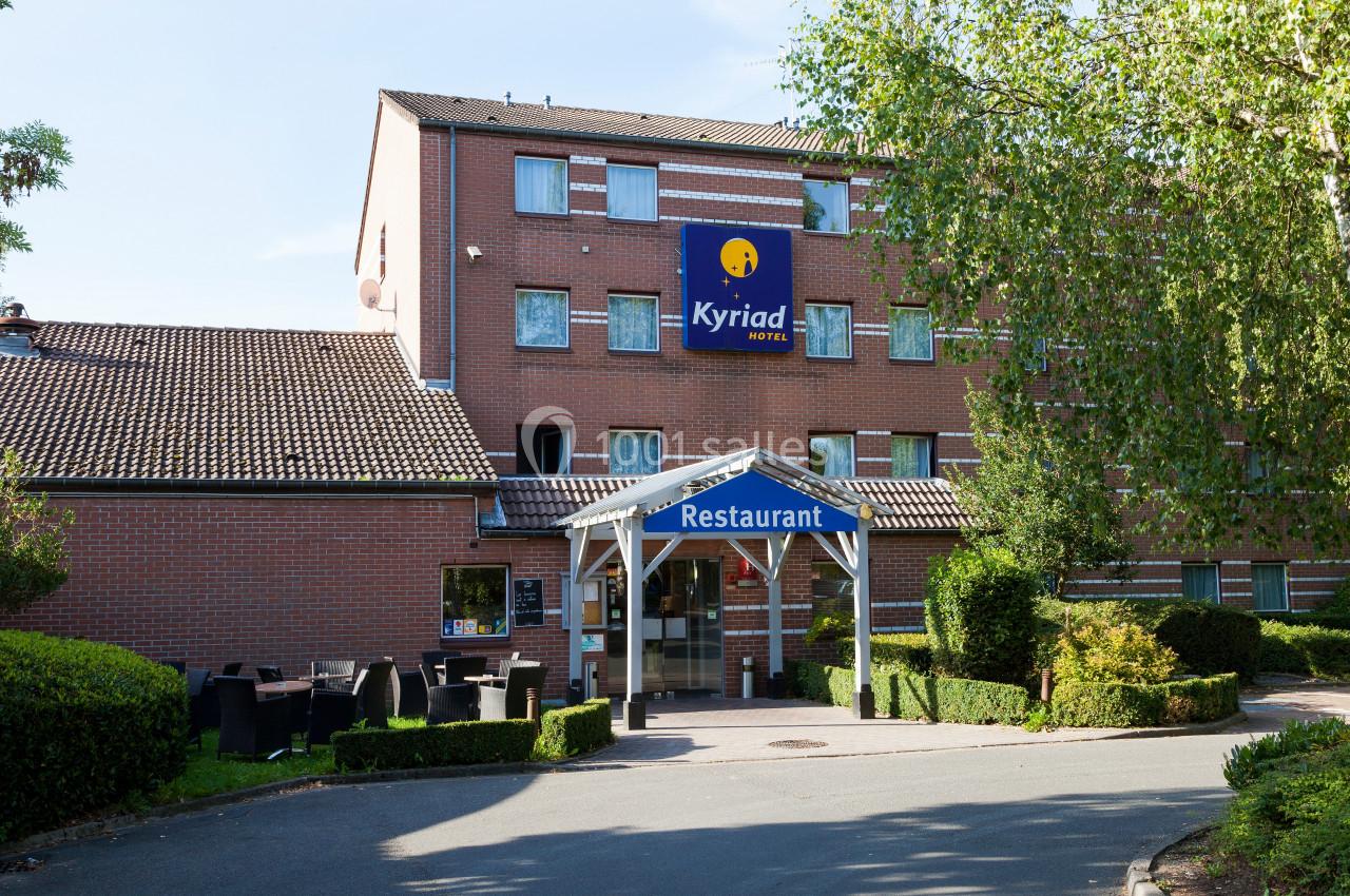 Façade d'un hôtel en briques rouges avec un panneau ’Kyriad’ et une entrée de restaurant sous un auvent.