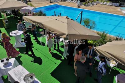 Salle de casino avec machines à sous illuminées, chaises noires et décor moderne sous un plafond sombre.