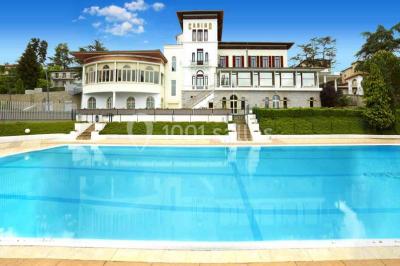 Salle de casino avec machines à sous illuminées, chaises noires et décor moderne sous un plafond sombre.