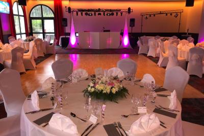 Salle de casino avec machines à sous illuminées, chaises noires et décor moderne sous un plafond sombre.