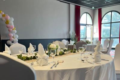 Salle de casino avec machines à sous illuminées, chaises noires et décor moderne sous un plafond sombre.