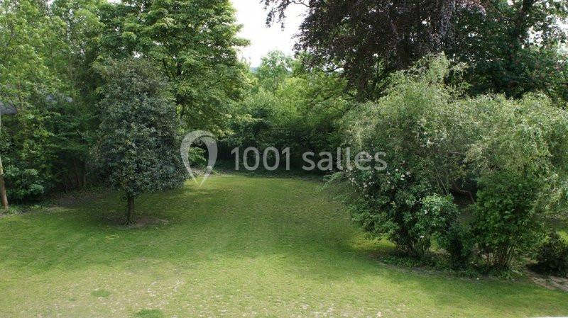 Location salle Farciennes (Hainaut) - Château Oxyjeunes #14 Pelouse entourée d'arbres et de buissons dans un espace verdoyant.
