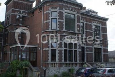 Miniature Location salle Farciennes (Hainaut) - Château Oxyjeunes #18 Grande maison en briques rouges avec deux tours, entourée de pelouse et de voitures garées devant.