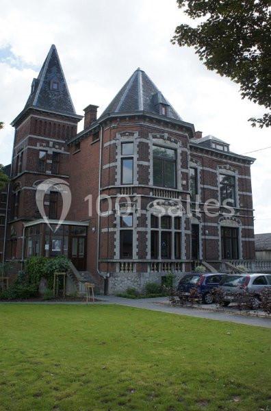 Location salle Farciennes (Hainaut) - Château Oxyjeunes #18 Grande maison en briques rouges avec deux tours, entourée de pelouse et de voitures garées devant.